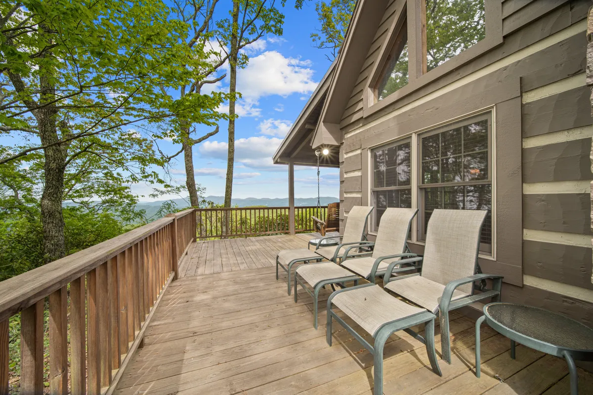 A pair of inviting deck chairs rests on a wooden balcony, overlooking sweeping mountain vistas. The serene setting is perfect for quiet mornings, sunset drinks, or stargazing, with the natural beauty of the region on full display.